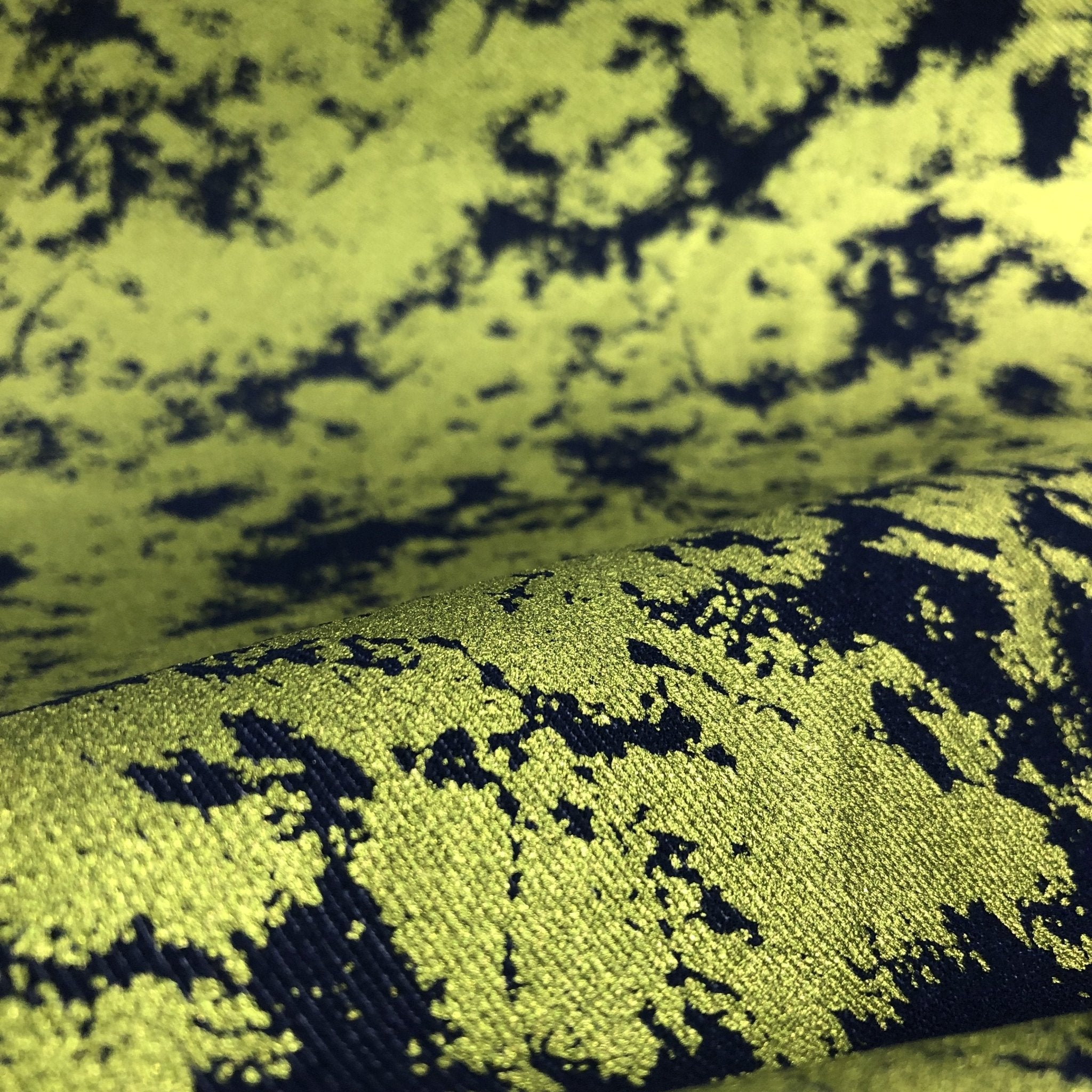 A draped sample of jolt foiled stretch faux denim in the color lime.