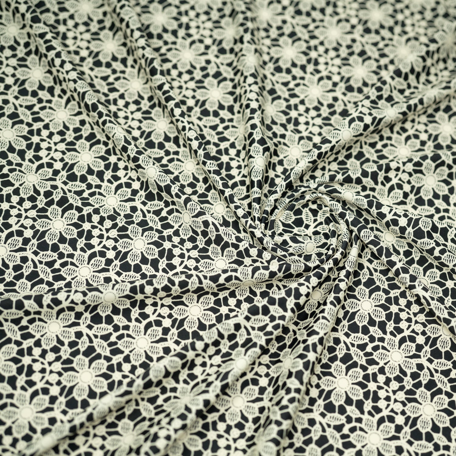 Swirled sample shot of vory Flower Lace Pattern on Black Printed Spandex