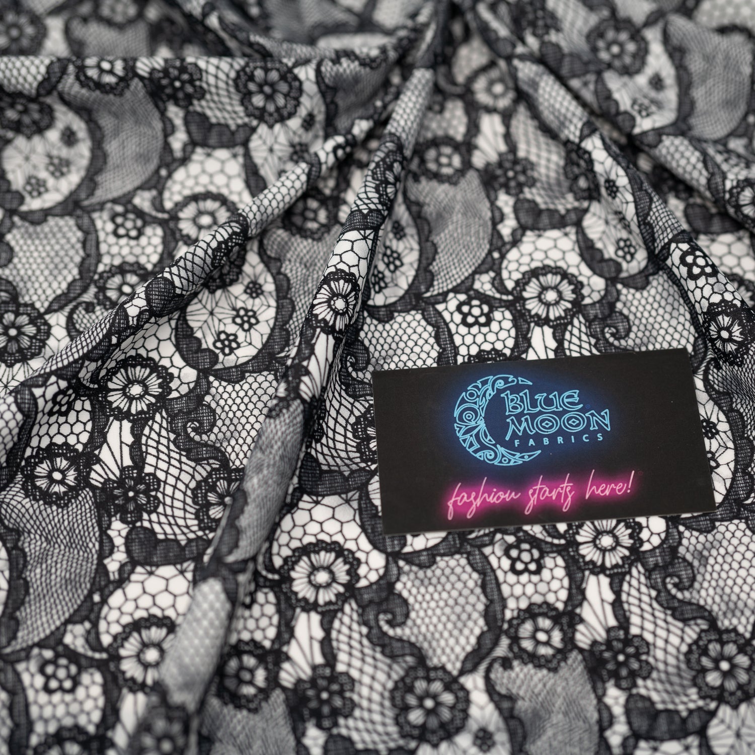 Swirled piece of Black Paisley Lace Pattern on White Printed Spandex