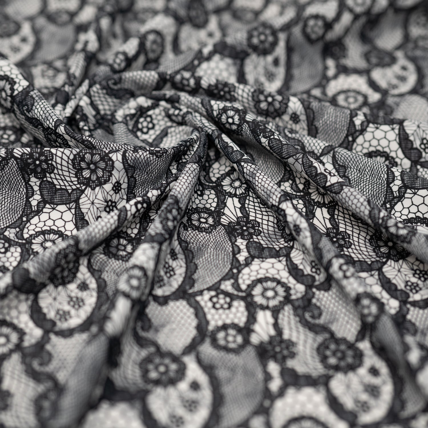 A crumpled piece of Black Paisley Lace Pattern on White Printed Spandex