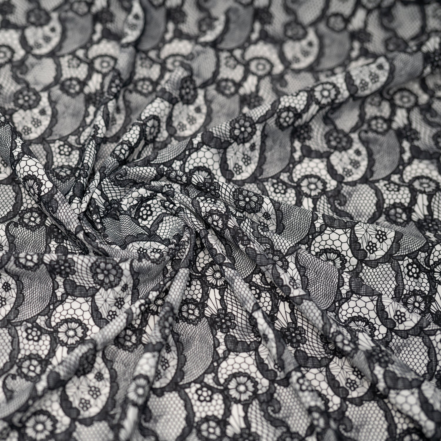 A crumpled piece of Black Paisley Lace Pattern on White Printed Spandex