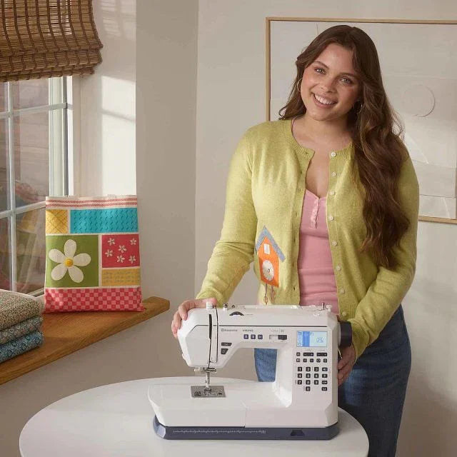 A photo of a woman with the HUSQVARNA VIKING ONYX 30 sewing machine.