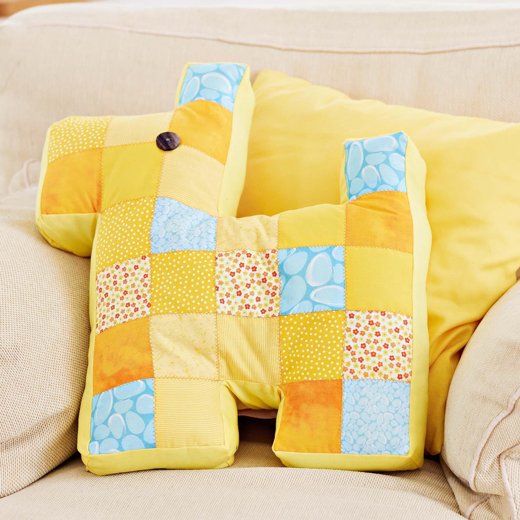 A yellow pillow with patches sewn using HUSQVARNA VIKING OPAL 650 Sewing Machine.