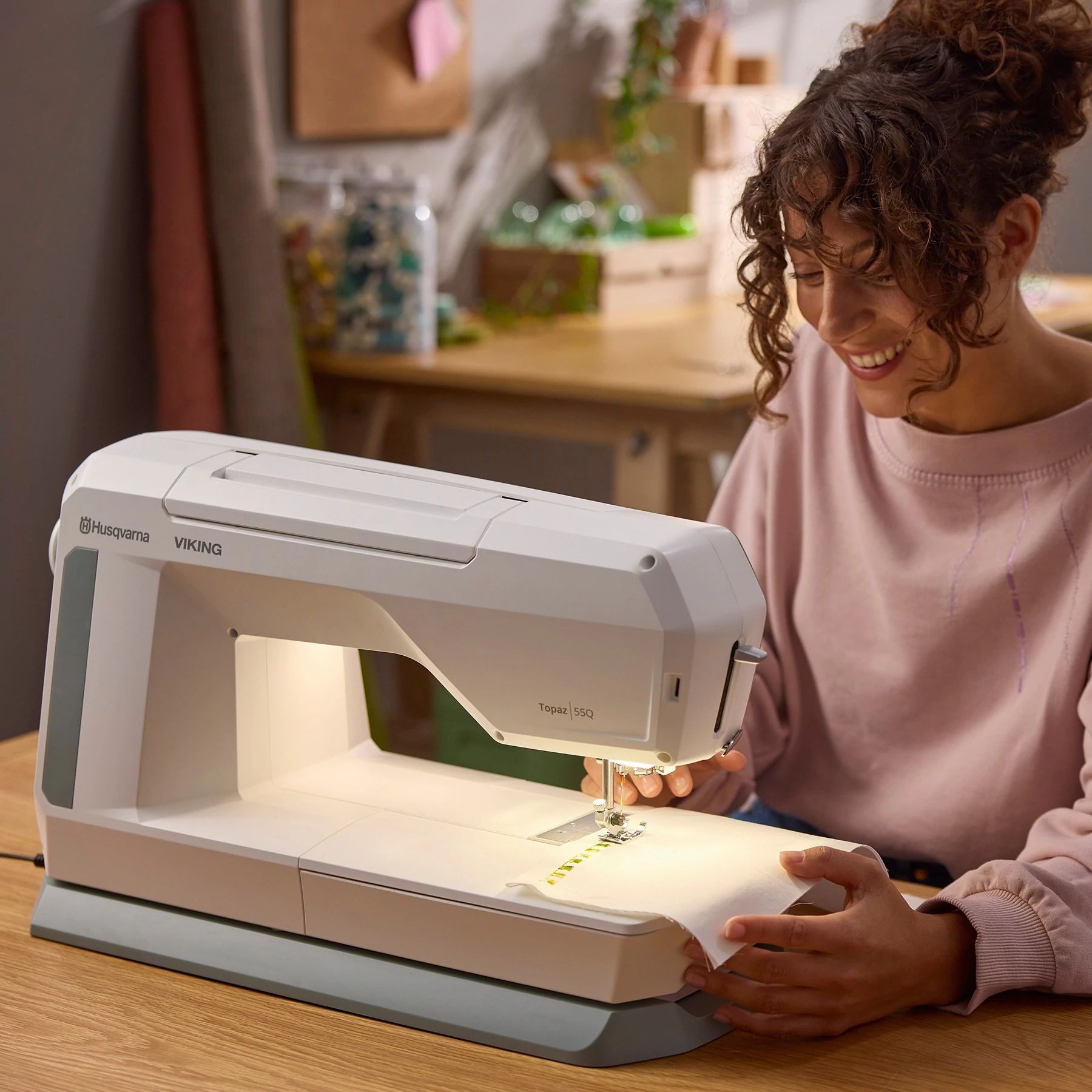A person sewing with HUSQVARNA® VIKING® TOPAZ™ 55Q Sewing Machine.
