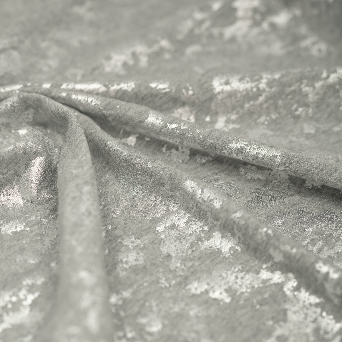 A crumpled piece of Cloud 9 Foil Printed Brushed Terry Fleece in the color Gray/Silver