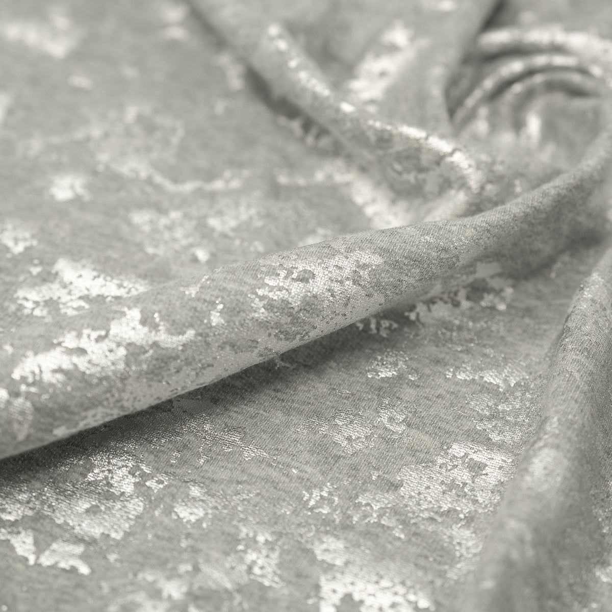 A crumpled piece of Cloud 9 Foil Printed Brushed Terry Fleece in the color Gray/Silver
