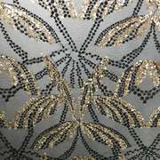 A flat sample of dragonfly mesh sequin in the color black-gold.