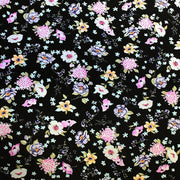 A flat sample of wild flowers on black printed spandex.