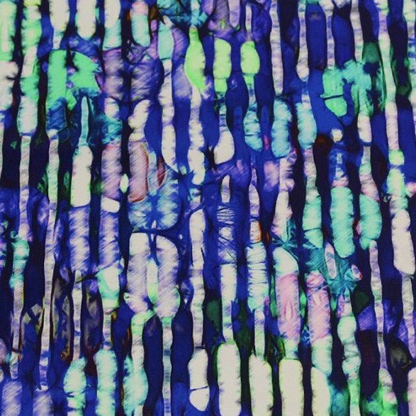 A flat sample of distressed blue and green printed spandex.