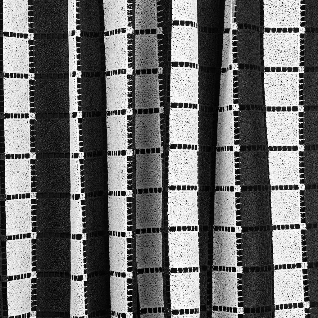 A draped sample of spade mechanical lace in the color black and white.
